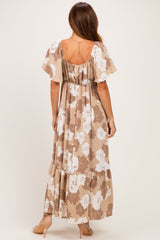 woman wearing a taupe floral print maxi dress with short flutter sleeves and a tiered skirt
