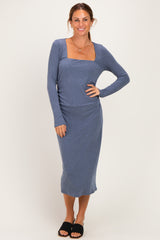 woman wearing a blue long sleeve midi dress with a square neckline and ruching details