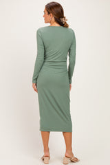 woman wearing a long sleeve ribbed green midi dress, showing the back view and styled with a hair clip
