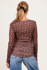woman wearing a brown long sleeve maternity top with a floral print, showing the back view
