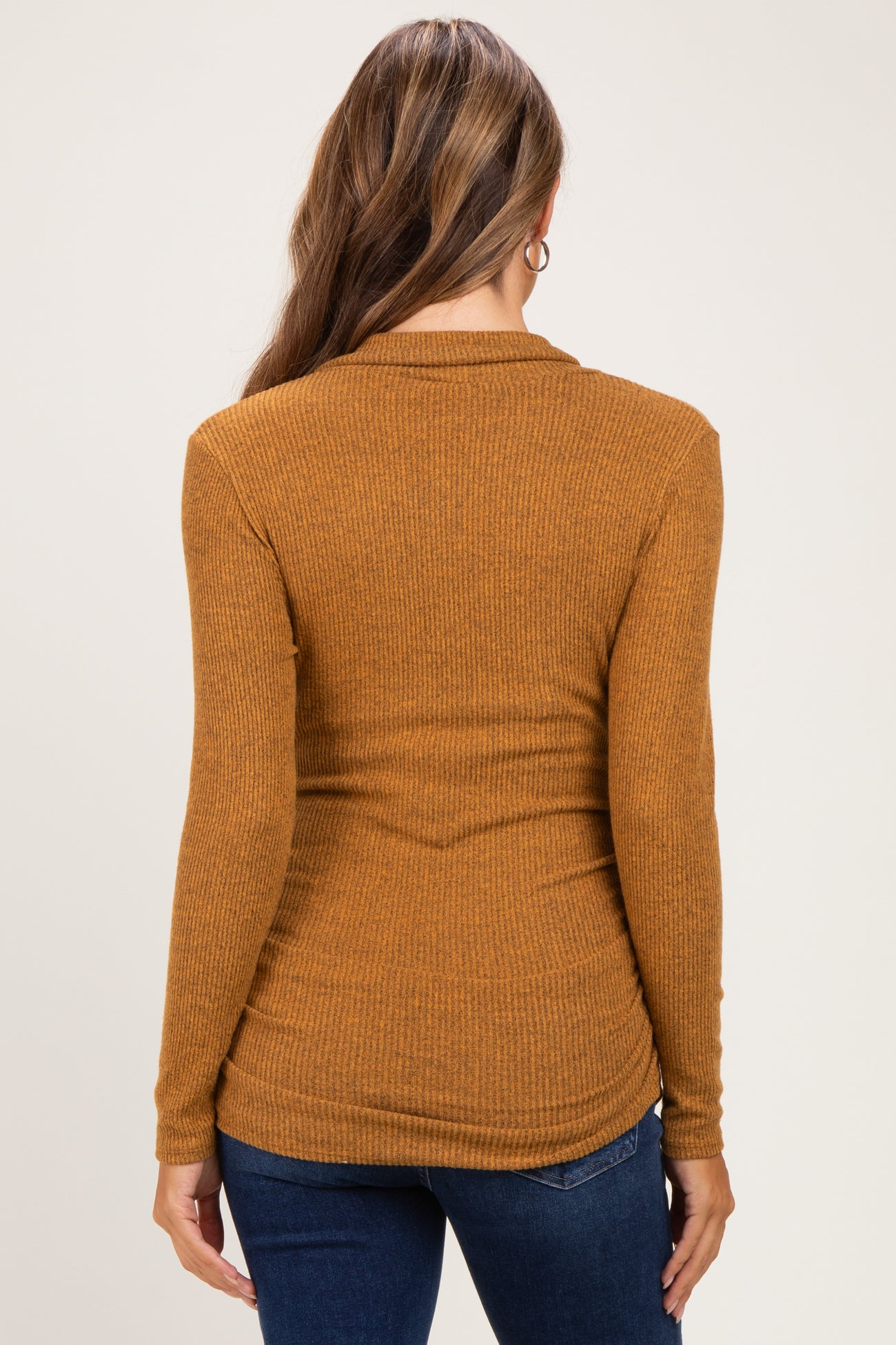 woman wearing a mustard ribbed long sleeve maternity top, viewed from the back