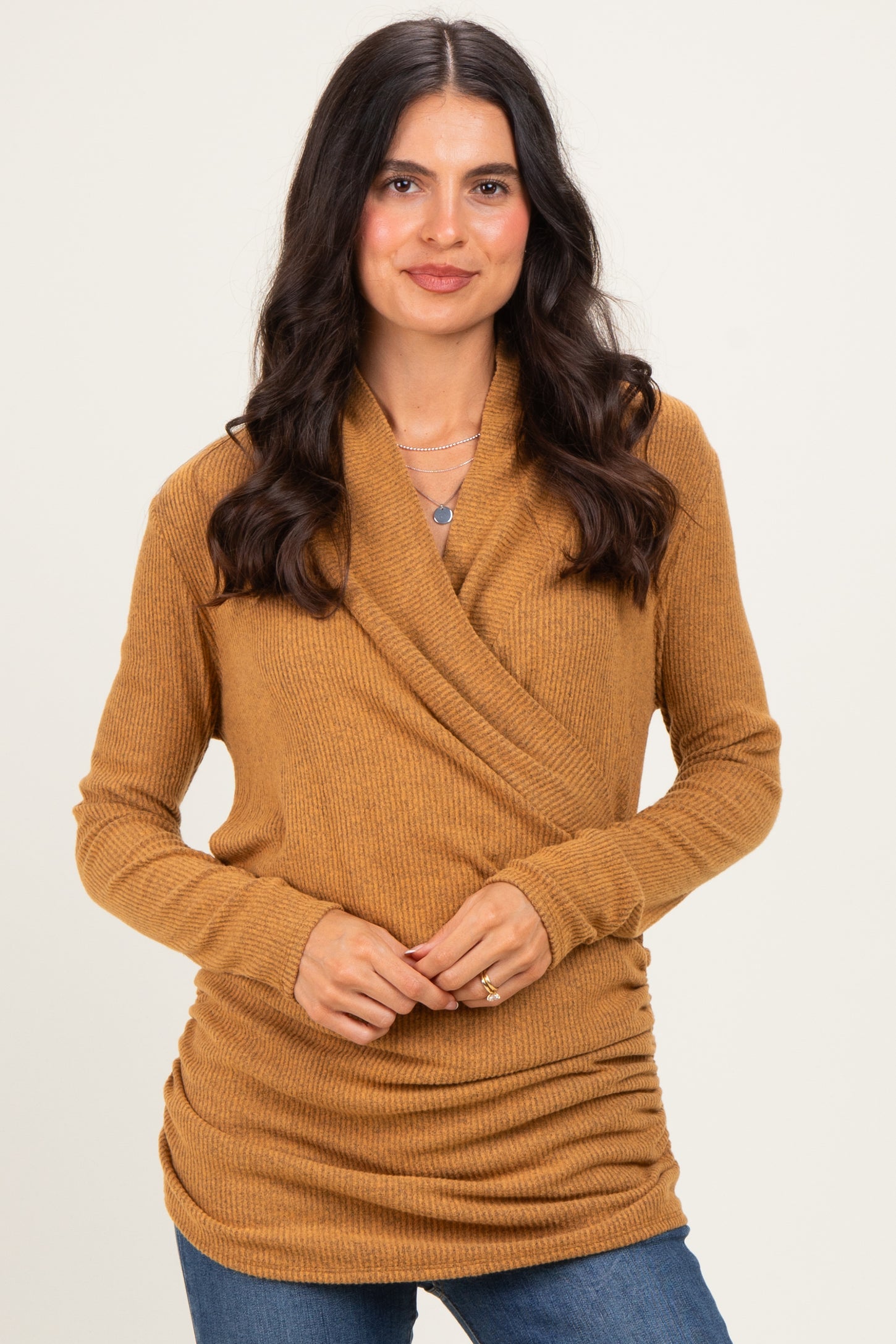 woman wearing a warm mustard long sleeve wrap top with gathered sides and a casual fit