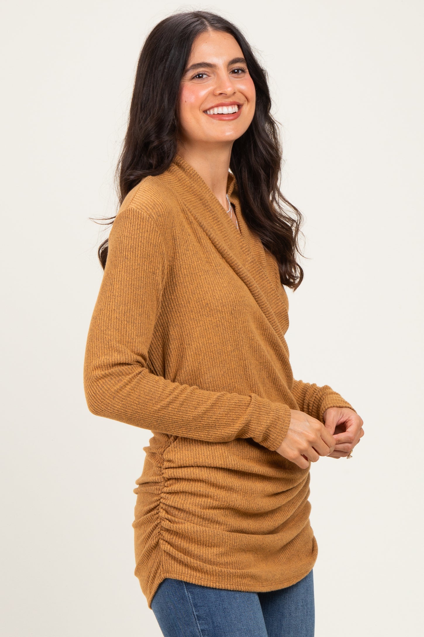 woman wearing a mustard-colored long sleeve wrap top with gathered sides and a relaxed fit