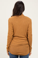 woman wearing a mustard yellow long sleeve ribbed top, viewed from the back