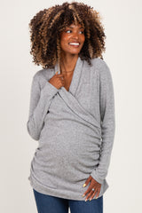 woman wearing a gray wrap maternity top with ruching detailing and a visible baby bump, styled casually with jeans