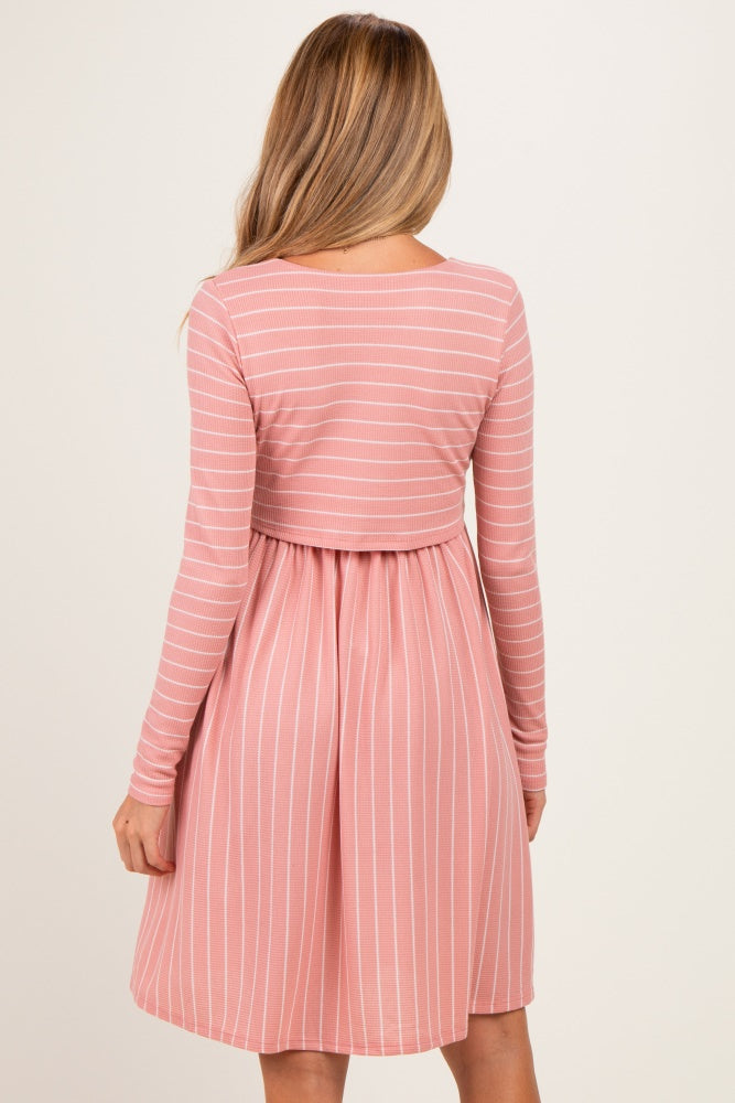 woman wearing a pink and white striped maternity dress with long sleeves and a gathered waist
