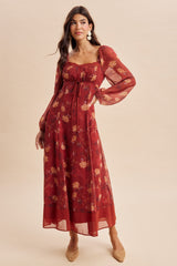 woman wearing a burgundy long sleeve floral maxi dress with a square neckline and gathered detail at the waist
