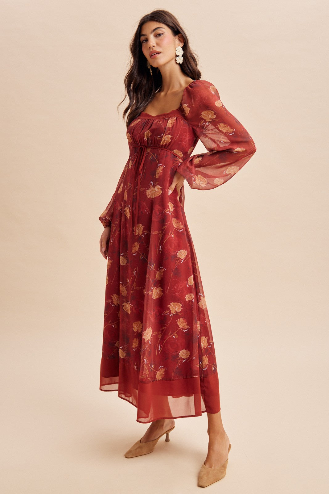 woman wearing a burgundy floral maxi dress with puffed sleeves and a square neckline, styled with beige heels