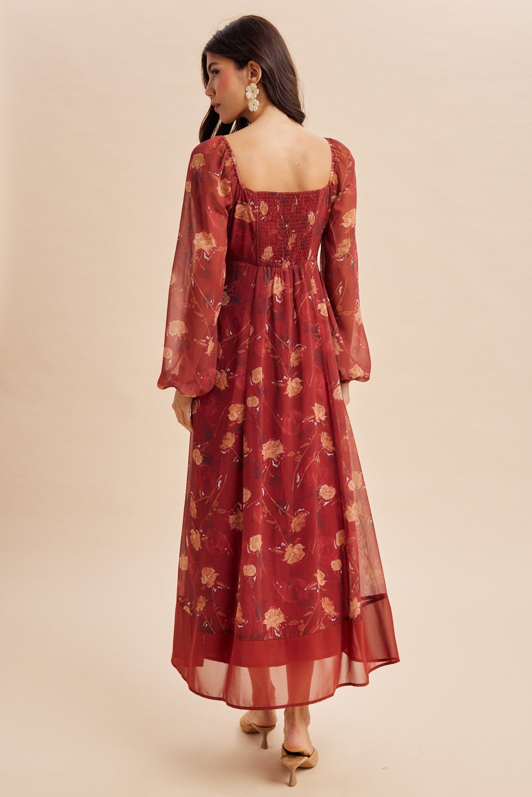 woman wearing a red floral maxi dress with long sleeves and a smocked back detail