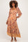 woman wearing a floral print maternity maxi dress with long sleeves and a tie waist, showcasing her baby bump