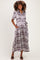 woman wearing a purple and white plaid maternity maxi dress with short sleeves and a tie waist, showing her baby bump