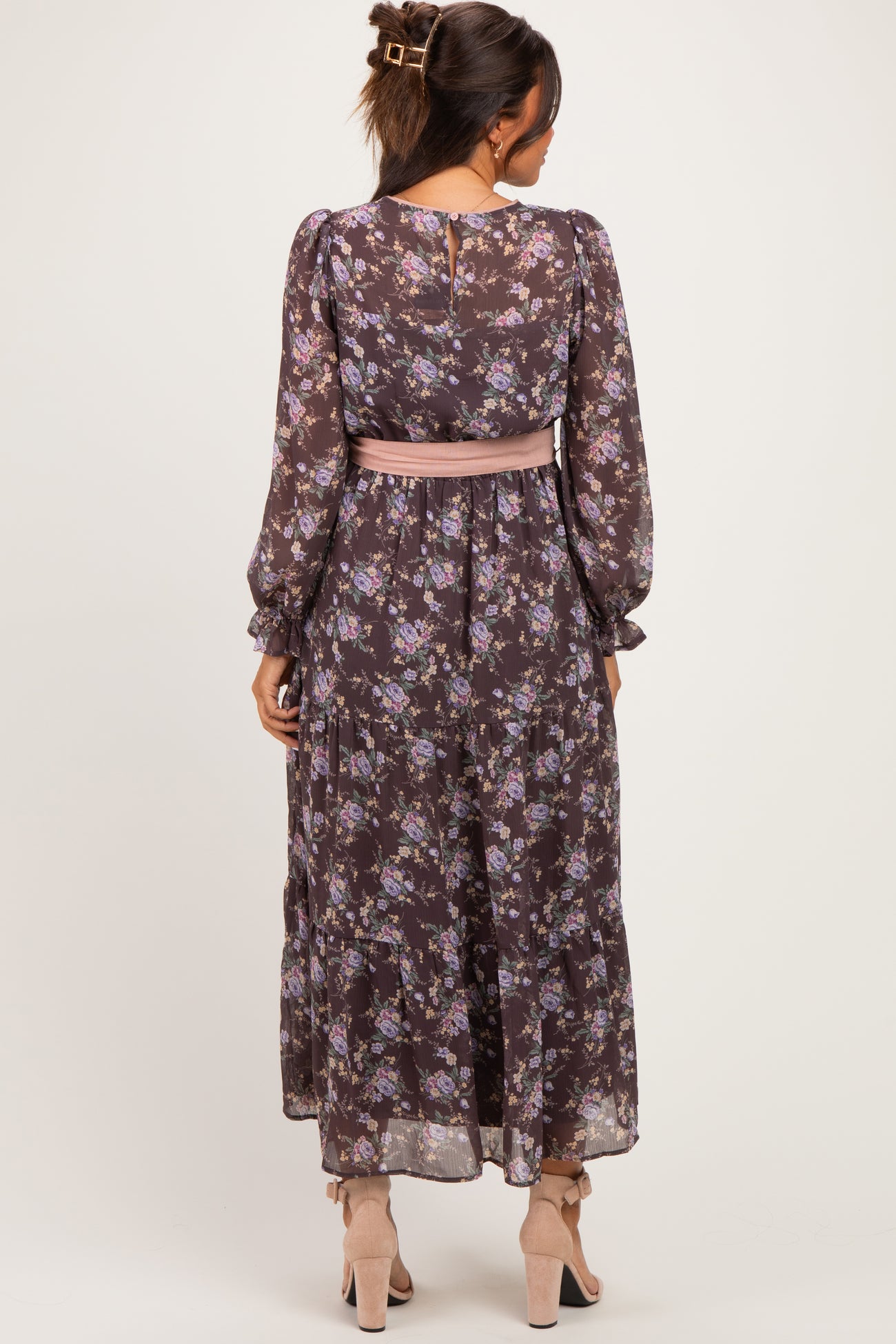 woman wearing a floral long sleeve maternity maxi dress with a pink sash, showing a baby bump from the back