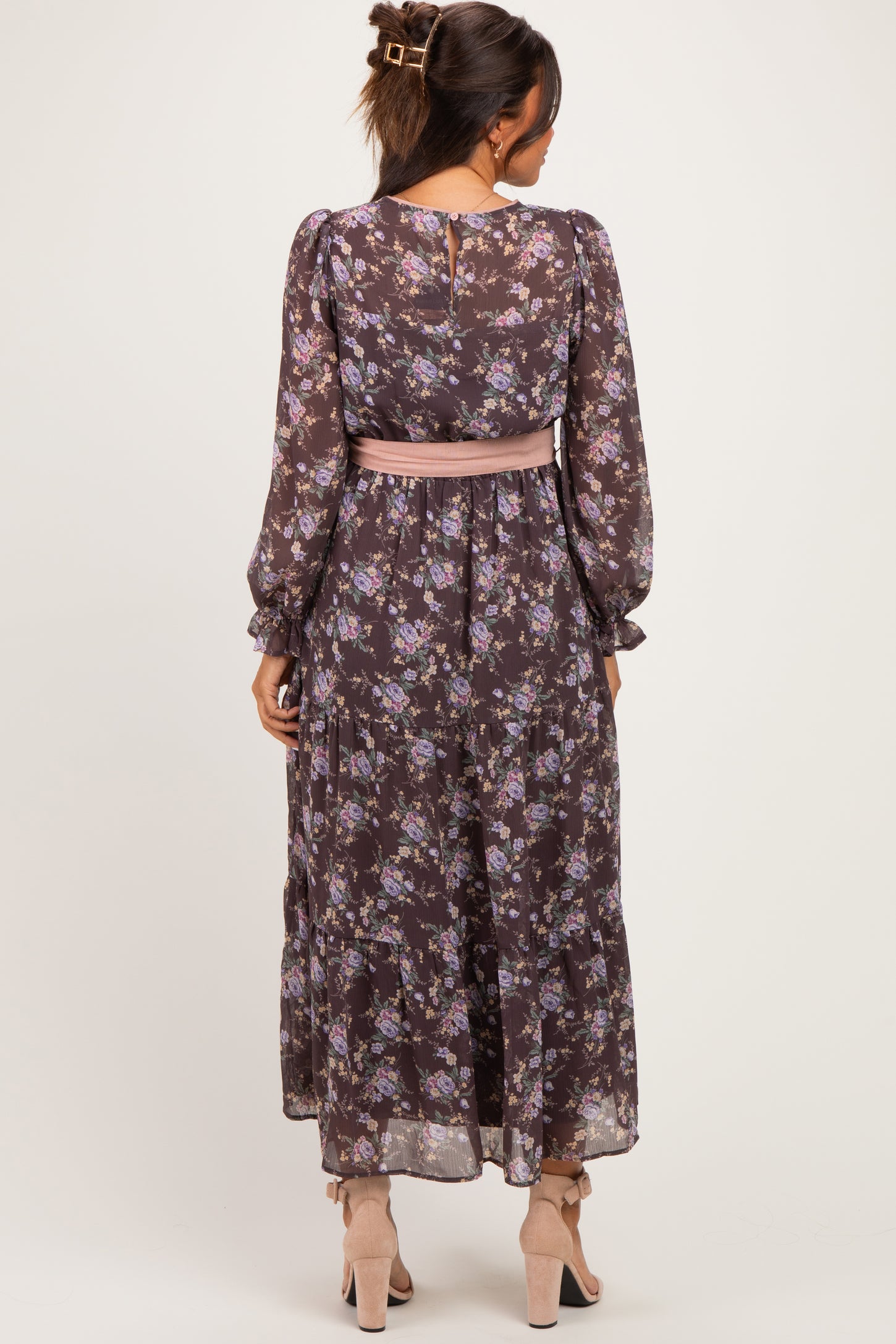 woman wearing a floral long sleeve maternity maxi dress with a pink sash, showing a baby bump from the back