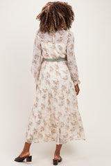 woman wearing a cream floral maternity maxi dress with long sleeves and a tie at the waist