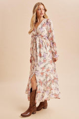 woman wearing a floral maxi dress with a deep v-neck and long sleeves, paired with brown cowboy boots