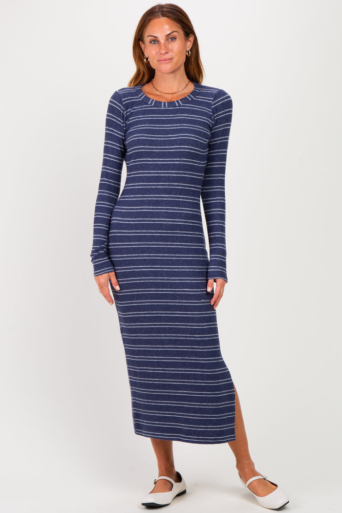 woman wearing a navy blue striped long sleeve maxi dress with a side slit and round neckline