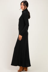 woman wearing a black long sleeve maxi dress with a mock neckline and side slit