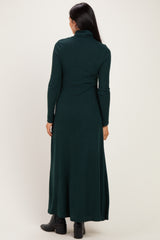 woman wearing a dark green ribbed maxi dress with a high neckline and long sleeves, shown from the back