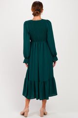 woman wearing a green long sleeve midi dress with smocked back and tiered skirt, seen from the back