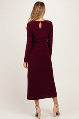 woman wearing a burgundy long sleeve maternity dress with a keyhole back detail