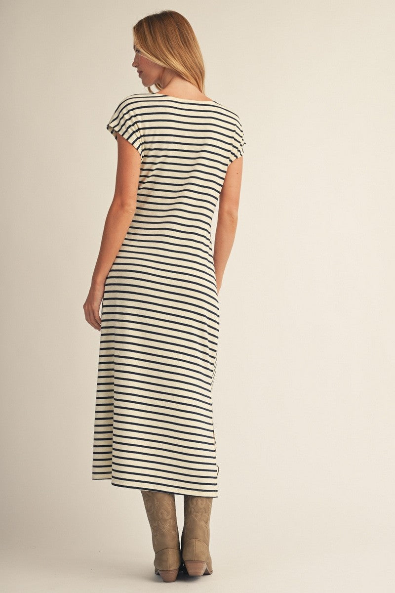 woman wearing a black and white striped maxi dress with short sleeves and a relaxed fit, viewed from the back