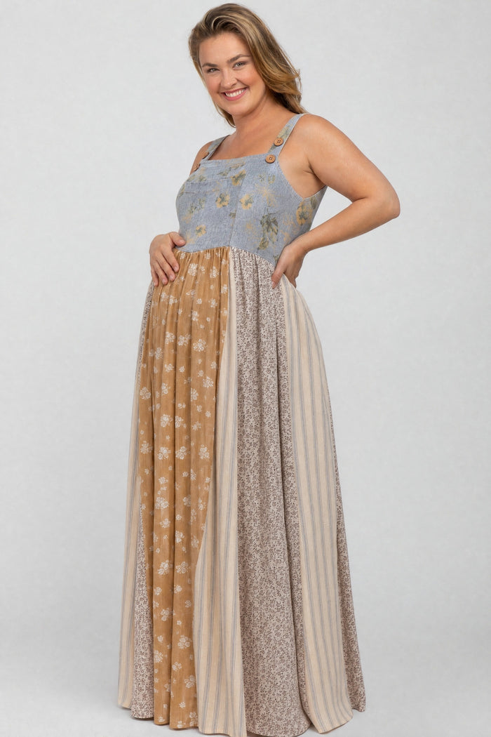 woman wearing a floral patterned maternity maxi dress with a blue top and multi-colored skirt, showing her baby bump
