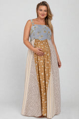 woman wearing a patchwork maternity dress with floral and striped patterns, cradling her baby bump