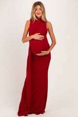 woman wearing a red sleeveless maternity gown with ruching, displaying her baby bump