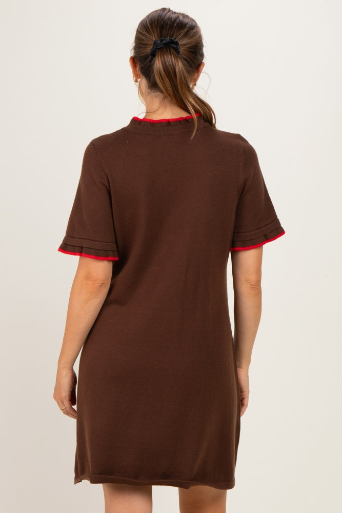 woman wearing a brown short sleeve maternity dress with red trim on the collar and sleeves, showing the back view