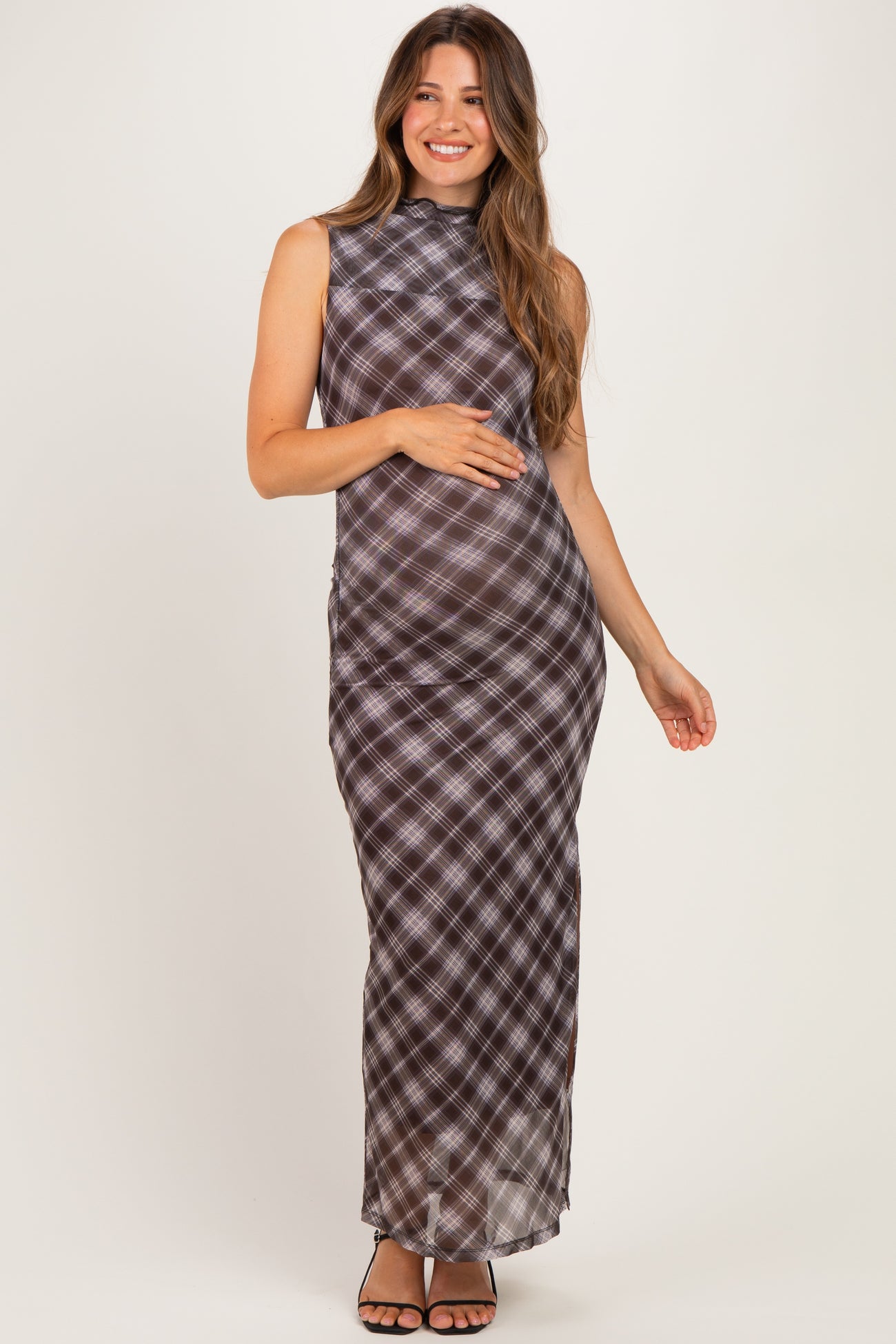 woman wearing a brown and black plaid maternity maxi dress with a high neckline and a visible baby bump