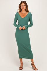 woman wearing a long sleeve green ribbed midi dress with a v-neckline and styled with strappy heels