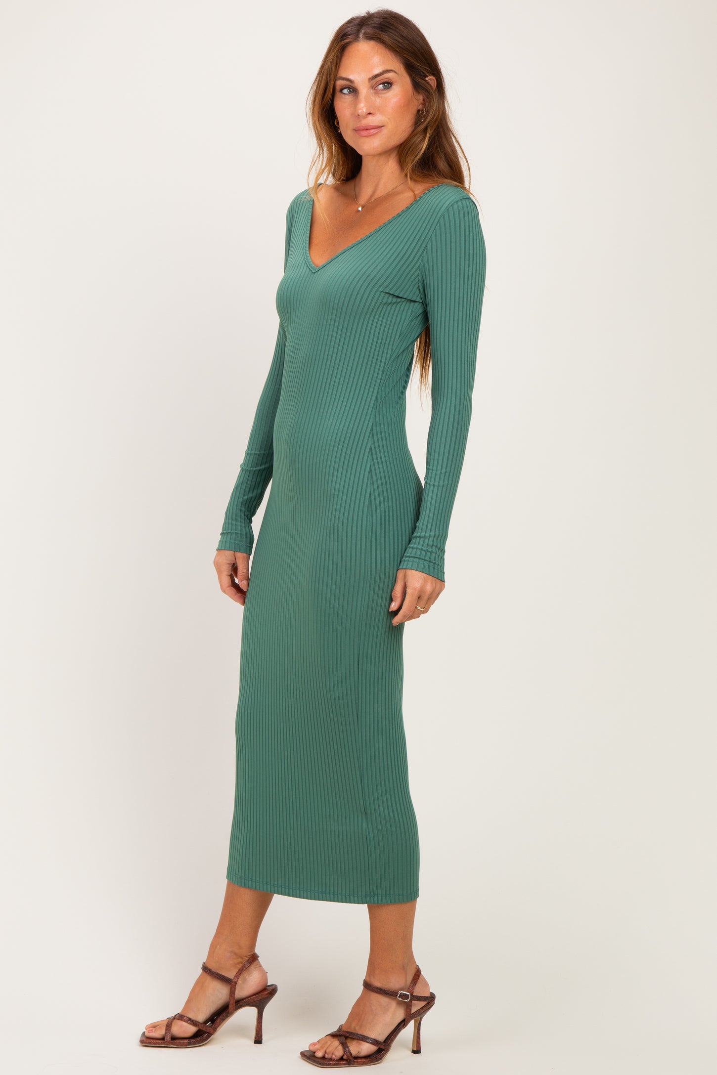 woman wearing a green ribbed long sleeve midi dress with a deep v-neck and fitted silhouette