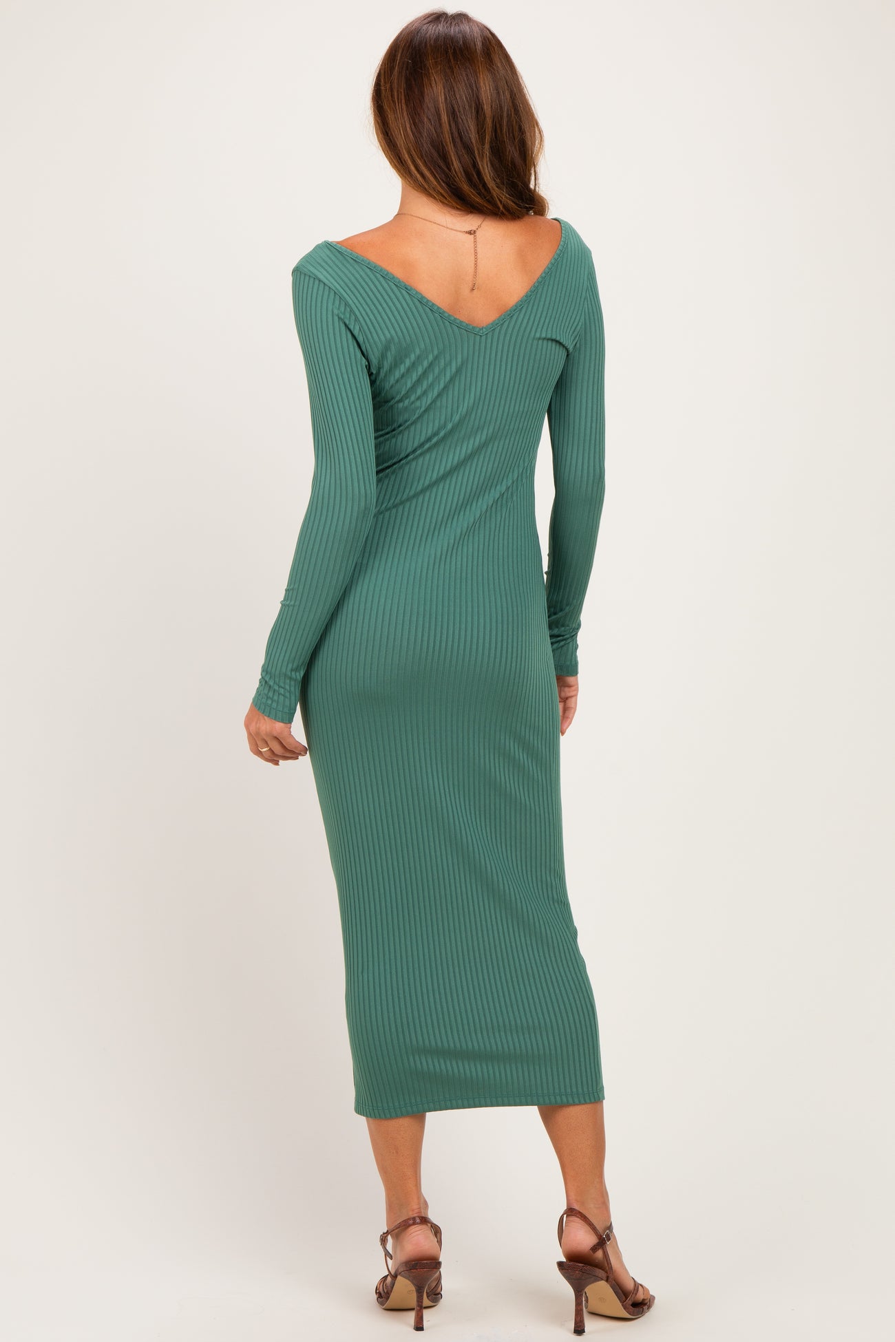 woman wearing a green ribbed midi dress with long sleeves and a v-back design