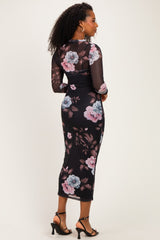 woman wearing a black floral midi dress with long sheer sleeves and a fitted silhouette