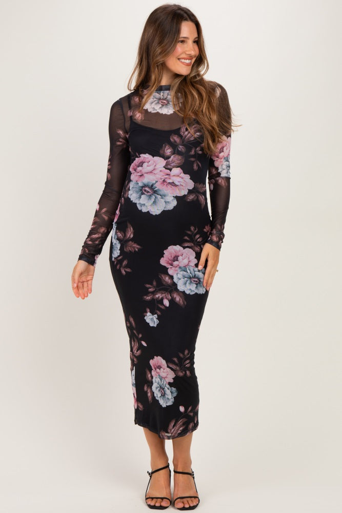 woman wearing a black floral maternity dress with long sleeves and a fitted silhouette
