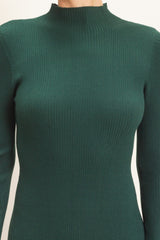 woman wearing a dark green ribbed turtleneck sweater with long sleeves