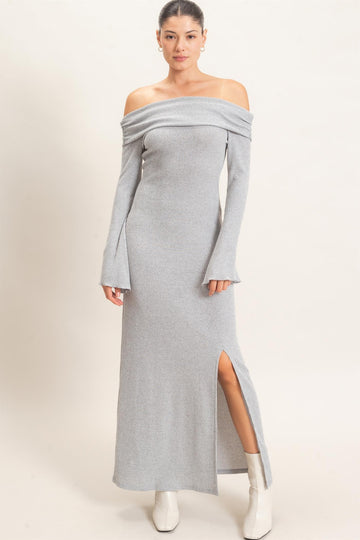 woman wearing a gray off-the-shoulder ribbed maxi dress with long sleeves and a side slit