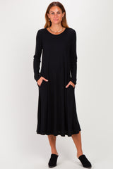 woman wearing a black long sleeve midi dress with pockets and a relaxed fit