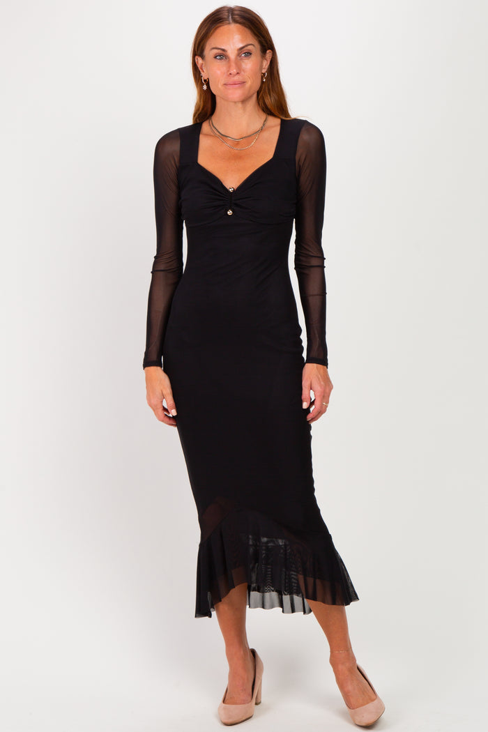 woman wearing a black long sleeve midi dress with a sweetheart neckline and ruffled hem
