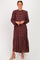 woman wearing a burgundy long sleeve tiered maxi dress with a floral pattern and ruffle neckline