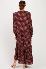 woman wearing a burgundy patterned long sleeve maxi dress with a tiered design and back keyhole detail