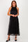 woman wearing a black halter neck midi dress with sequin details and a sheer overlay, styled with black heels