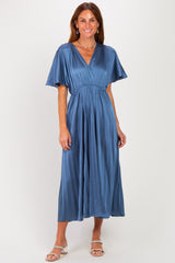 woman wearing a pleated midi dress in deep blue with short flutter sleeves and a cinched waist