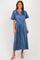 woman wearing a pleated midi dress in deep blue with short flutter sleeves and a cinched waist