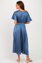 woman wearing a light blue pleated maxi dress with short flutter sleeves and an elastic waist, seen from the back