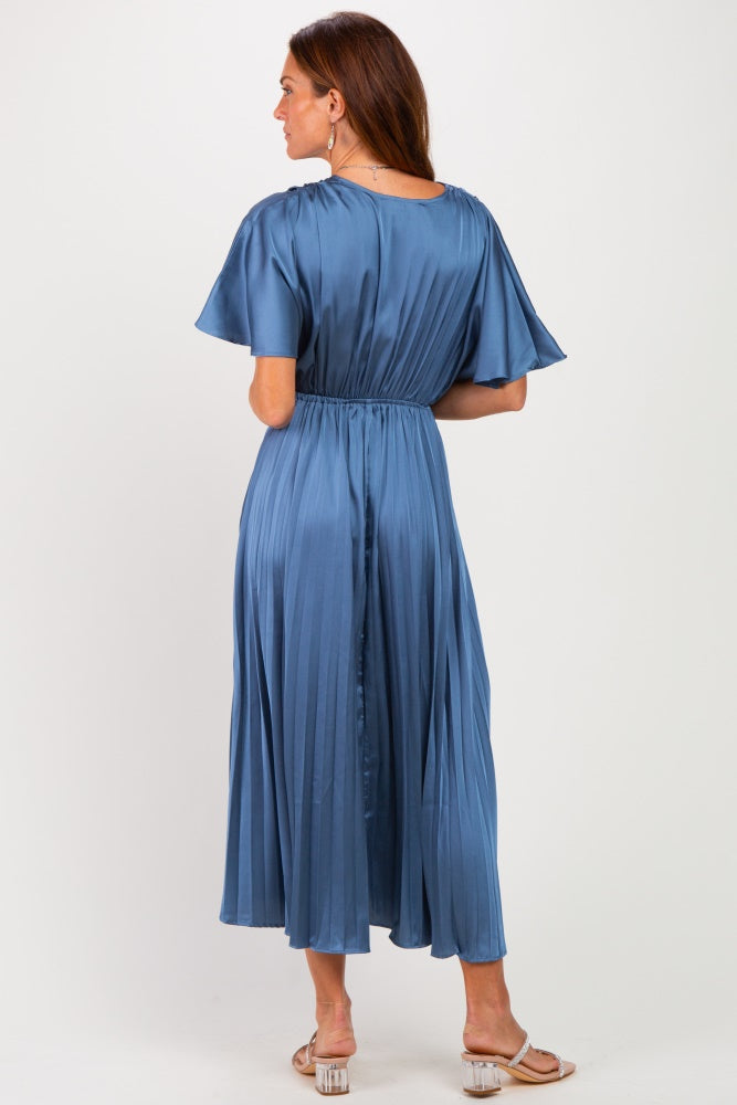 woman wearing a light blue pleated maxi dress with short flutter sleeves and an elastic waist, seen from the back