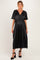 woman wearing a black maternity dress with short sleeves and a flowy skirt, showing her baby bump