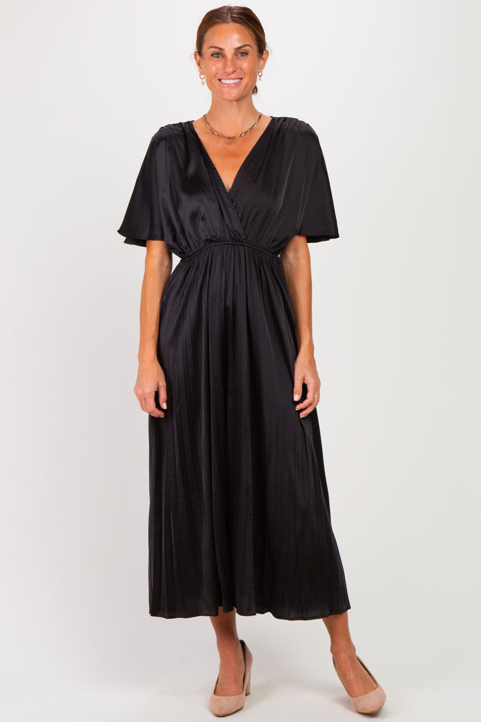 woman wearing a black satin maxi dress with a deep v-neck and short flutter sleeves, standing in a neutral pose