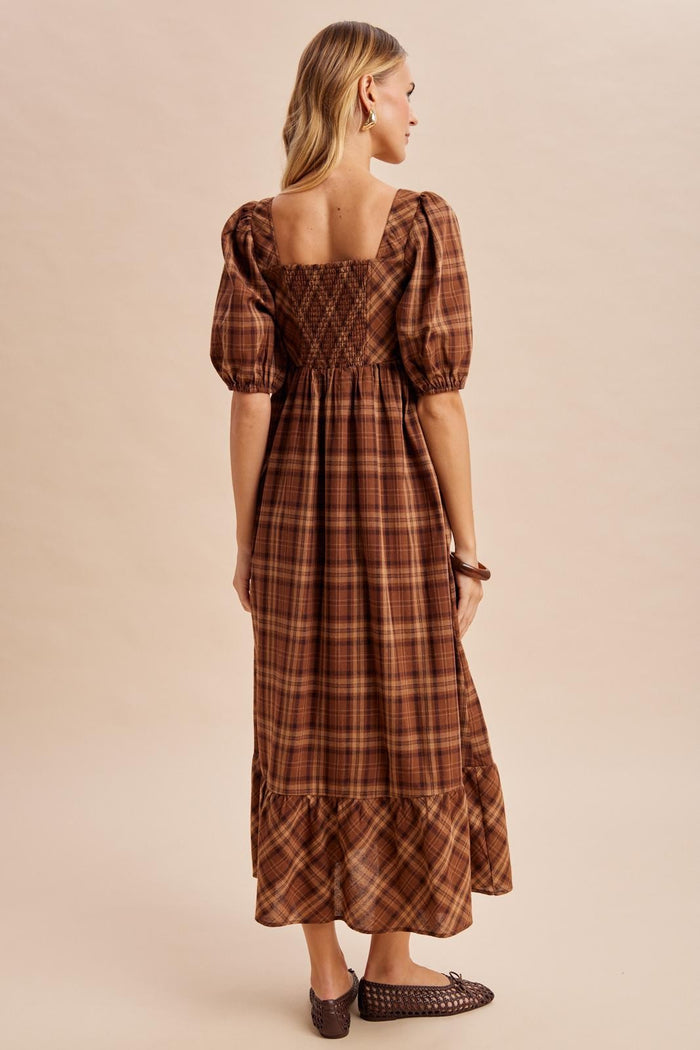 woman wearing a brown plaid long sleeve maxi dress with puffed sleeves and a smocked back detail