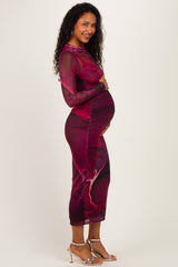 woman wearing a form-fitting pink and red patterned maternity dress showcasing her baby bump